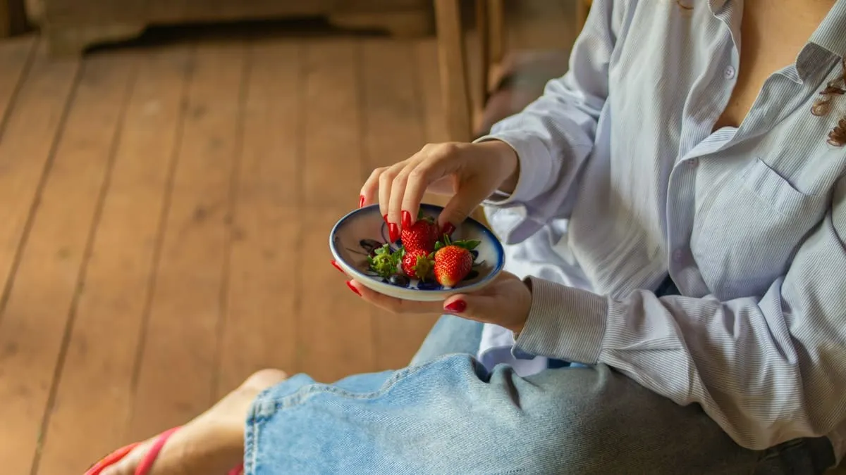 Афродизиаки для женщин: что говорят исследования. Woman holding a plate of fresh strawberries and blueberries Фото: Bruno Dias, Unsplash