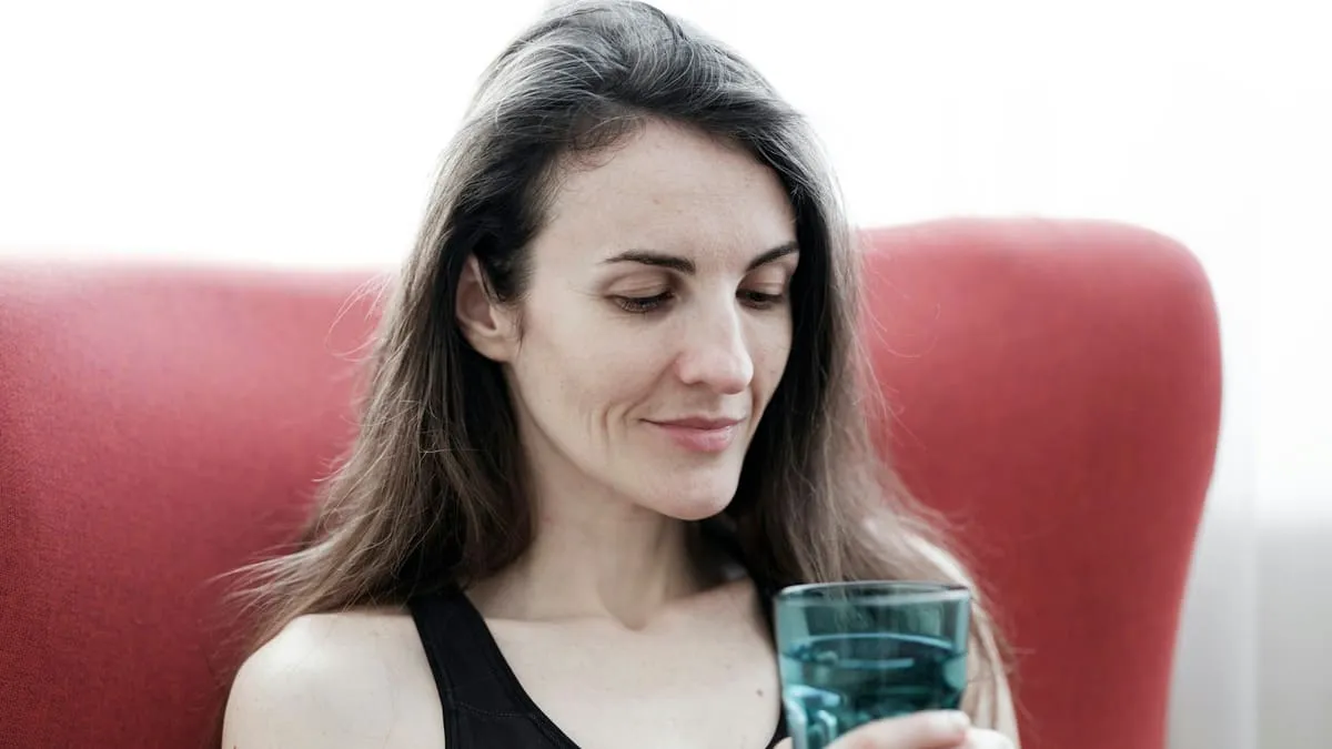Цистит после секса: почему бывает и как предотвратить. a woman sitting in a red chair holding a glass Фото: engin akyurt, Unsplash