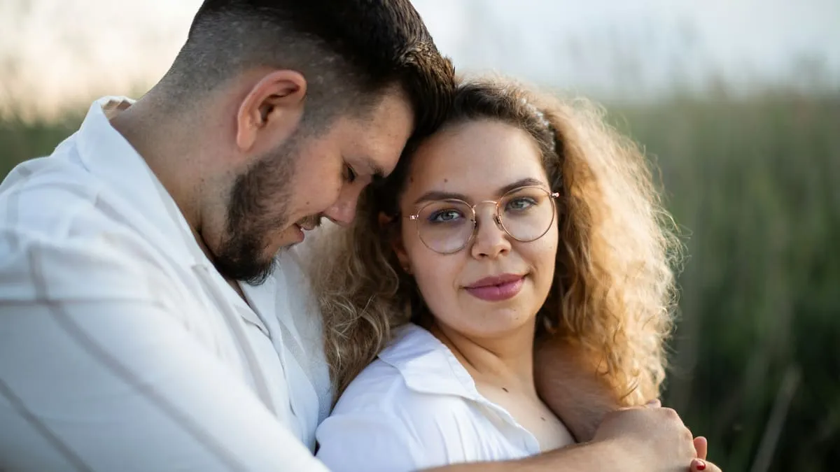 Люблю, но не хочу: что это значит и что делать. Loving couple: he embraces her, looking affectionate Фото: Marius Muresan, Unsplash
