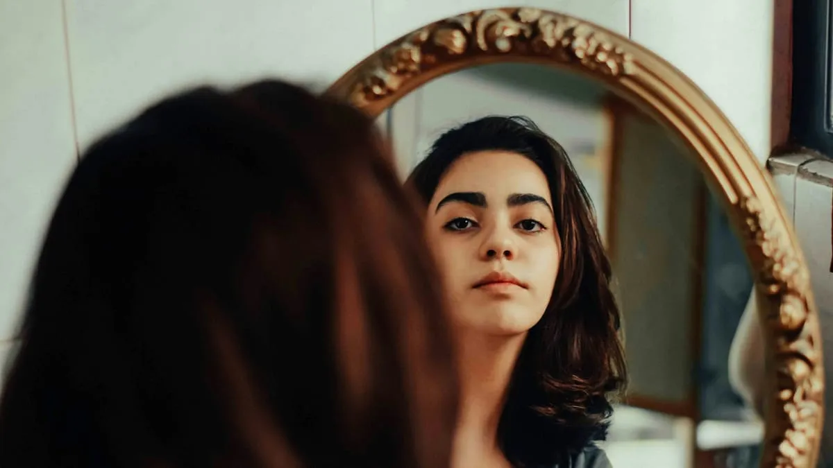 Любовь к себе и своему телу: как перестать стыдиться и сравнивать. A woman looking at her reflection in a mirror Фото: Negar Nikkhah, Unsplash