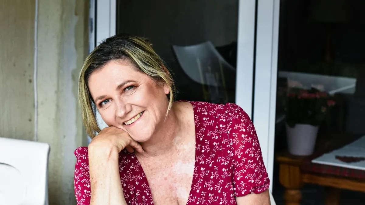 Менопауза и климакс: как понять, что началось, и что делать. a woman sitting at a table with a smile on her face Фото: Jacqui-Leigh Meyerson, Unsplash