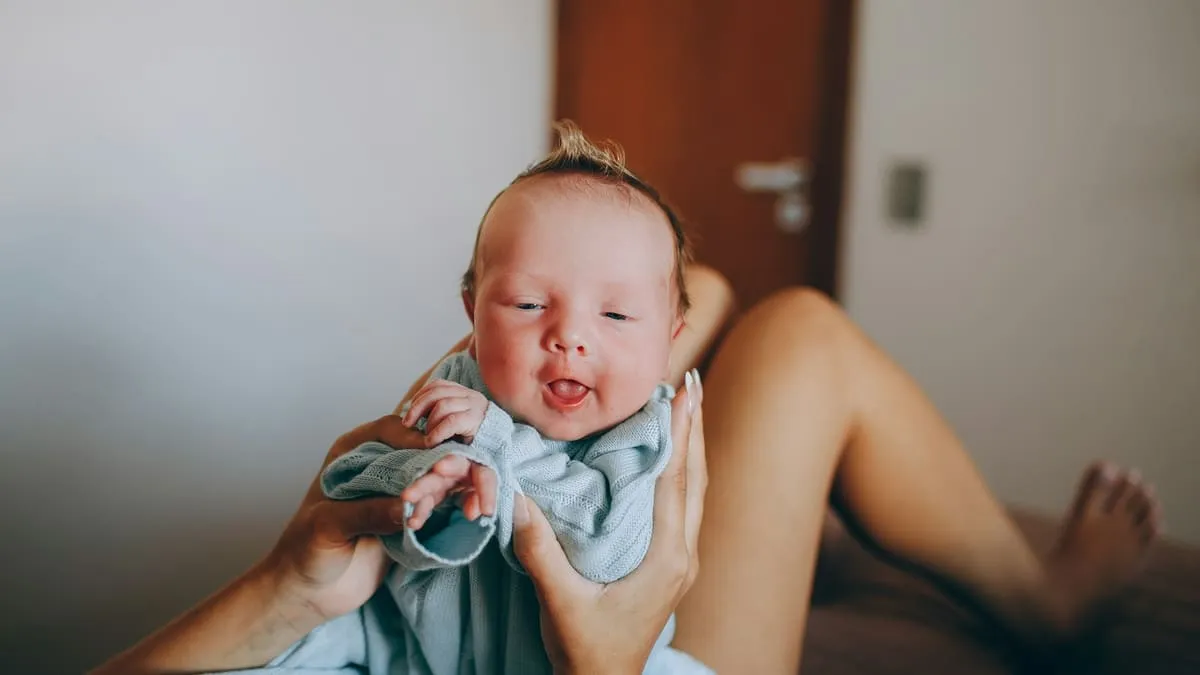 Не хочу мужа после родов: почему и когда вернётся желание. woman in white tank top carrying baby Фото: Helena Lopes, Unsplash