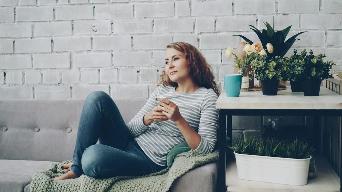 Вагинальный оргазм: есть ли он и чем отличается от клиторального. Woman relaxing on sofa with phone and coffee Фото: Vitaly Gariev, Unsplash
