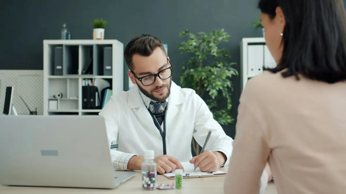 ЗППП и ВПЧ: что нужно знать. Doctor writing notes while patient sits opposite Фото: Vitaly Gariev, Unsplash